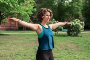 Junge Frau auf einer Raststätte macht Übung Schulterkreise