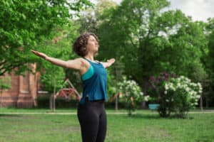 Junge Frau auf einer Raststätte macht Übung Brust Stretch