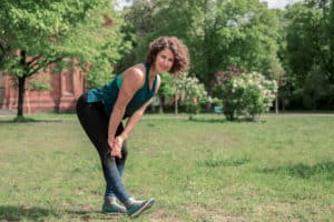 Junge Frau auf einer Raststätte macht Übung Bein Stretch