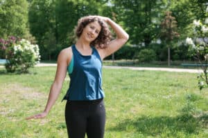 Junge Frau auf einer Raststätte macht Übung Nackenstretch