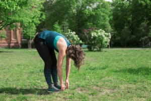 Junge Frau auf einer Raststätte macht Übung Roll Up