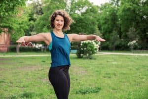 Junge Frau auf einer Raststätte macht Übung Torso Twist