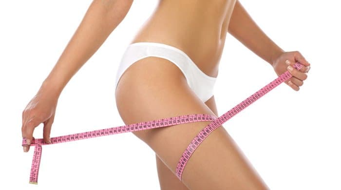 Frau mit Maßband am Oberschenkel