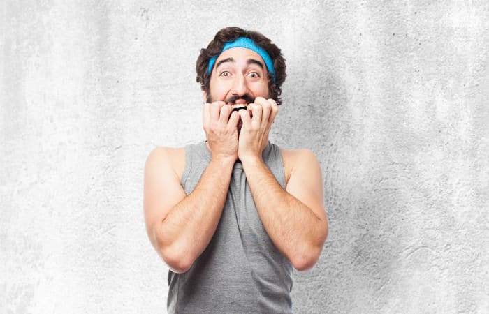 Mann in lustigem Sportoutfit schaut verängstigt