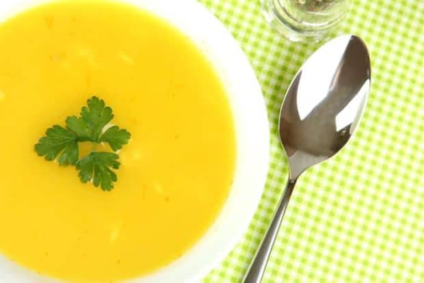 Möhren-Aprikosen-Suppe mit Petersilie in weißer Keramikschüssel