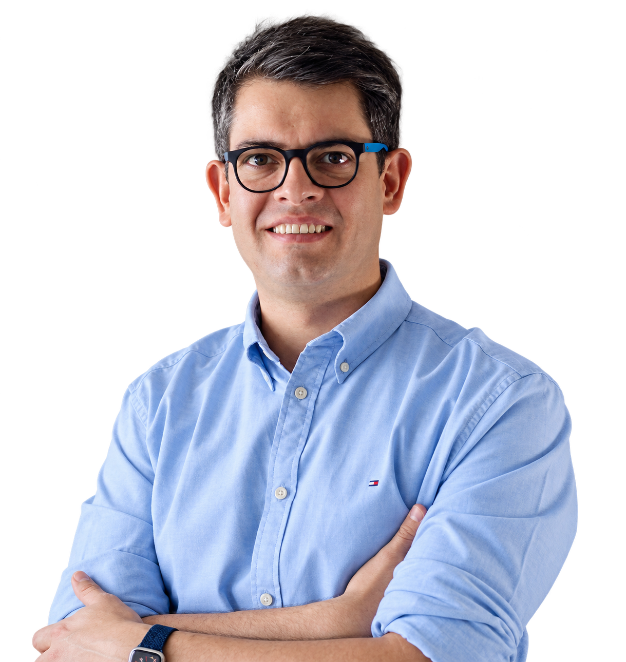 Juan Saavedra smiling with arms crossed, wearing glasses and a light blue shirt.