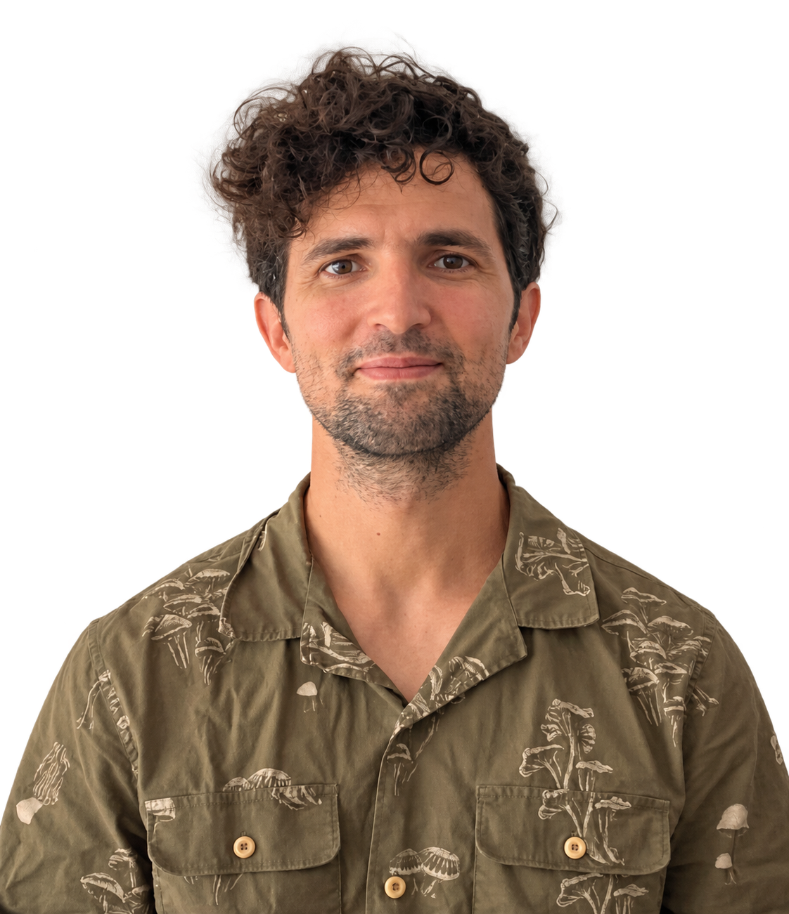 Man with curly dark hair and a beard wearing an olive green patterned shirt, facing the camera.