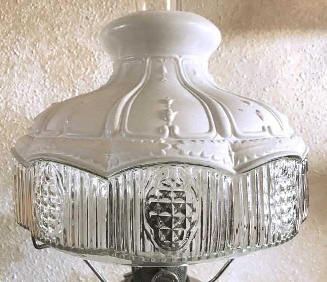 White and clear glass vintage lamp shade with embossed floral and geometric patterns.