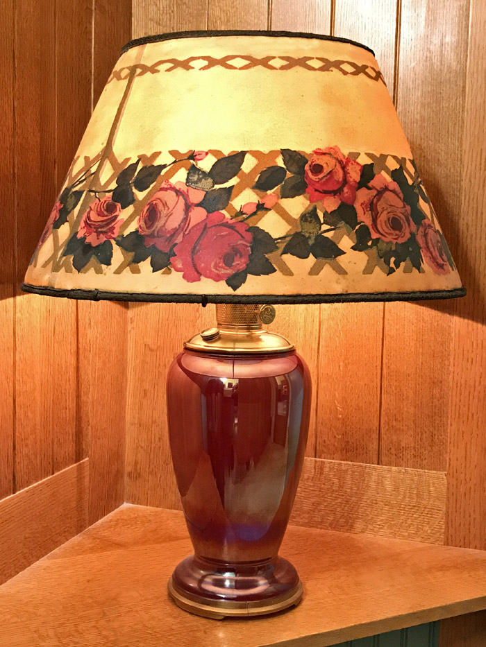 Table lamp with a purple ceramic base and a lampshade decorated with red roses and green leaves.
