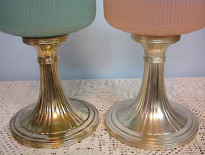 Close-up of two vintage silver goblet bases on a lace tablecloth, one green, one peach glass.