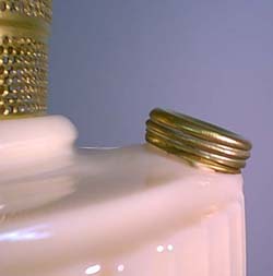 Several stacked gold rings placed on the edge of a white ceramic object against a blue background.