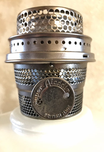 Close-up of a metal burner with perforations and a dial labeled 'Aladdin British Made'.