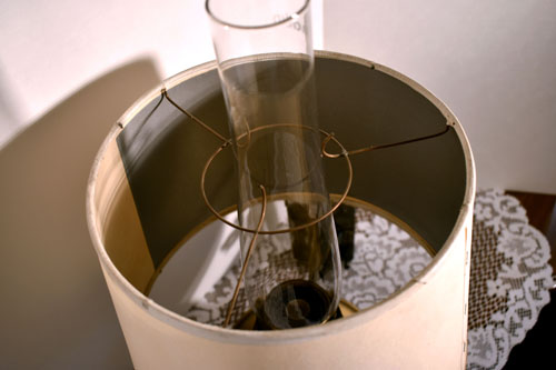 Close-up of a beige lamp shade with visible internal wiring and a clear glass lamp chimney.