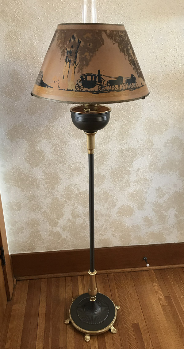 Tall vintage floor lamp with a painted lampshade depicting a horse-drawn carriage scene.