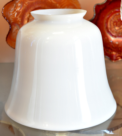 Glossy white ceramic vase with a wide base and narrow top on a reflective surface.