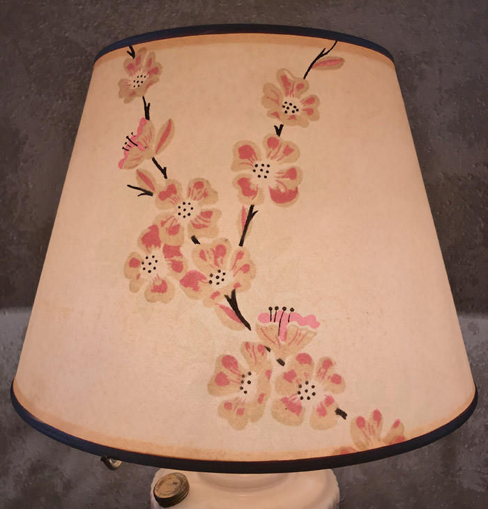 Beige lampshade with painted pink and tan floral branches and black outlines.