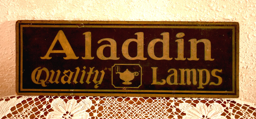 Vintage sign reading 'Aladdin Quality Lamps' with a lamp icon in the center.