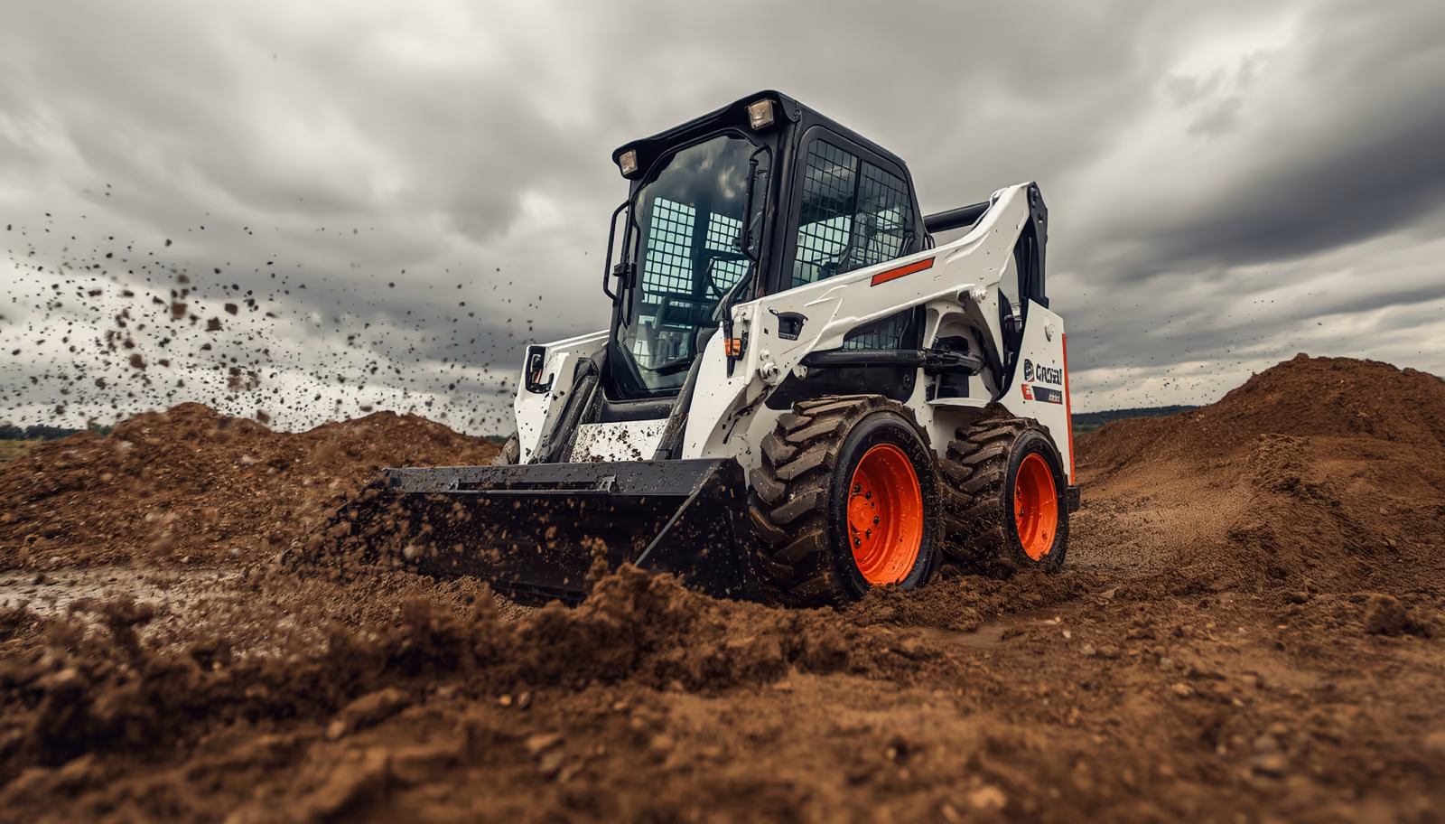 White skid steer loader with orange wheels moving and throwing dirt on a cloudy day at a construction site.