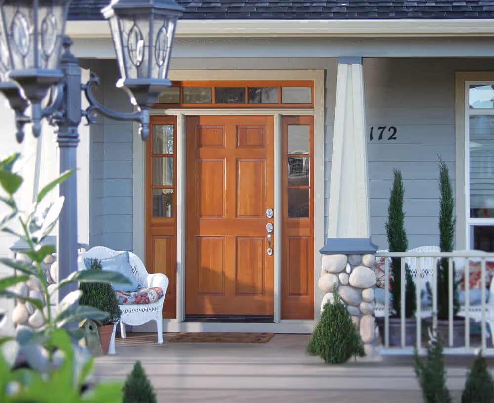 Wooden front door with glass side panels, stone pillar, and white wicker chairs on a porch numbered 172.