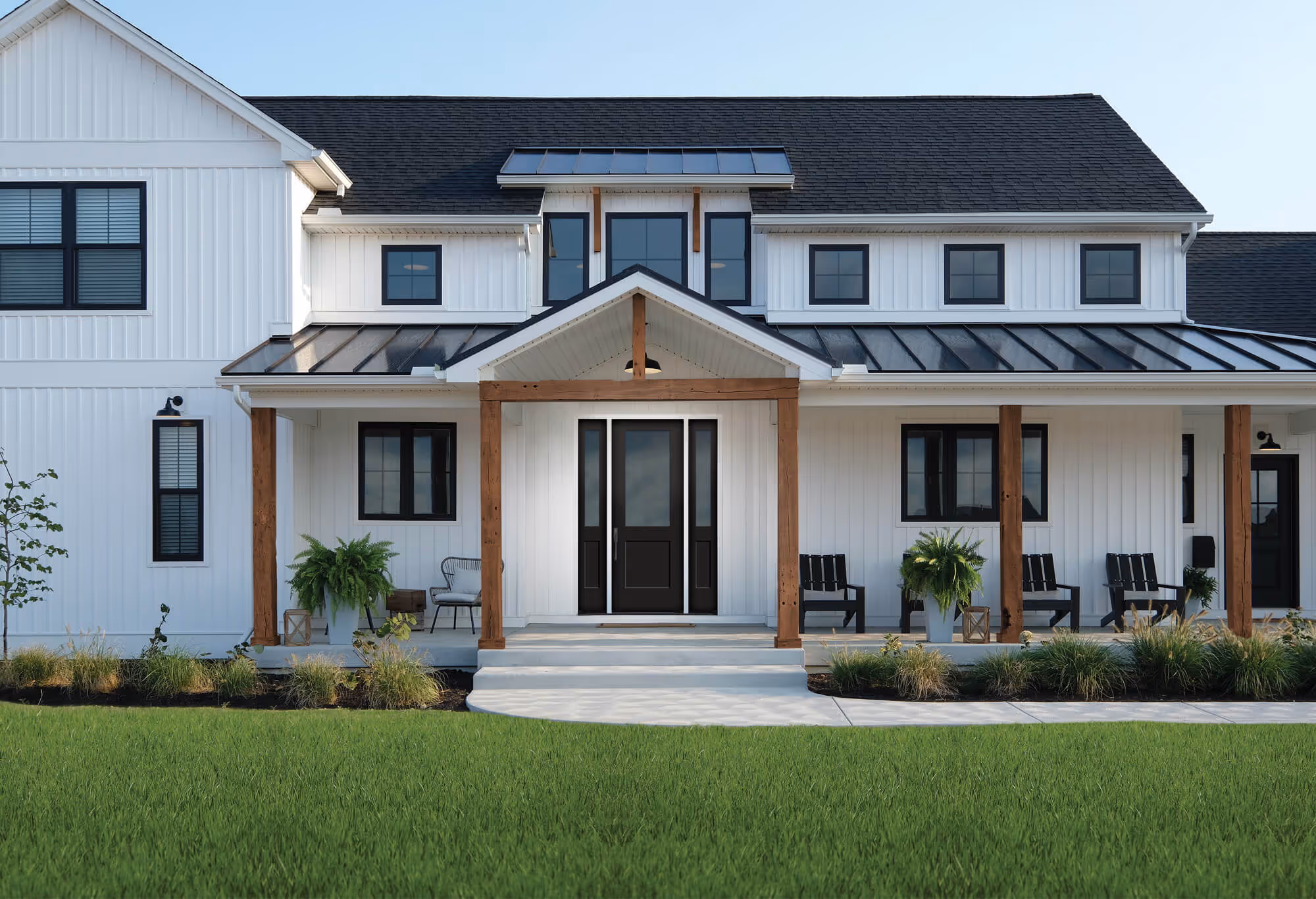 White modern farmhouse with black-framed windows, wooden porch posts, and a black front door with sidelights.