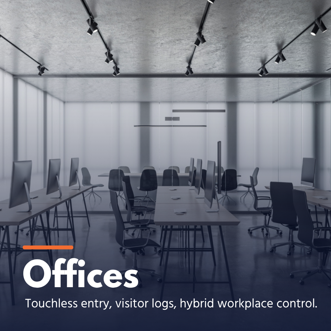 Modern office space with computer desks, chairs, and glass walls under ceiling lights.