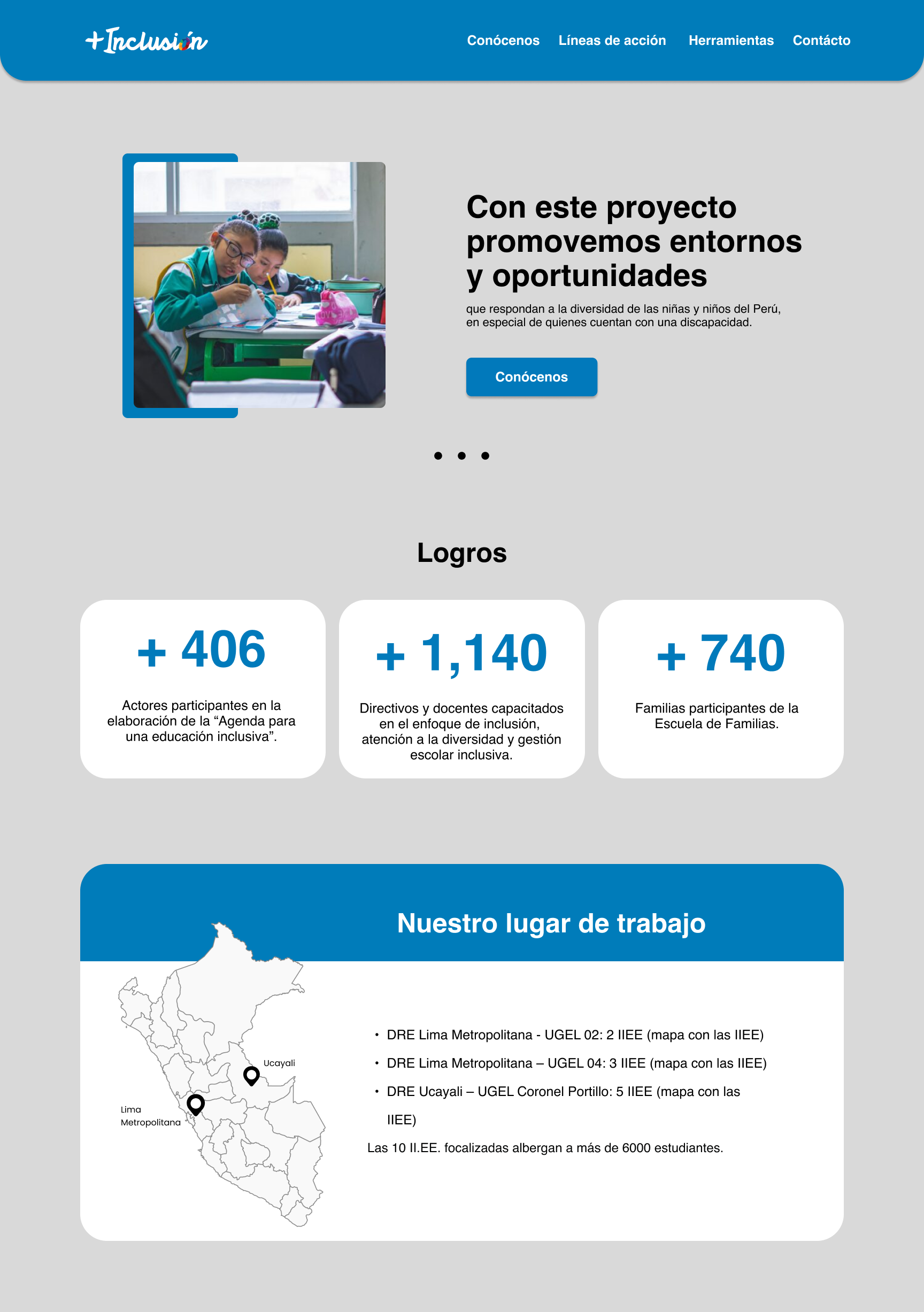 Two students in green uniforms working together at a desk in a classroom with a window in the background.