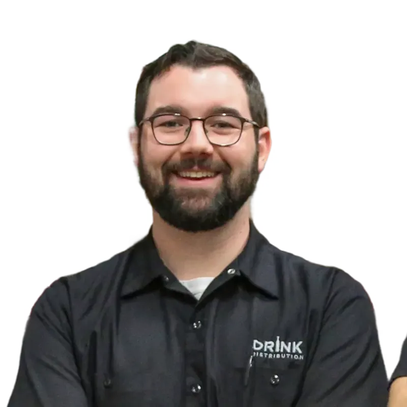 Smiling bearded man wearing glasses and a black shirt with Drink Distribution logo.