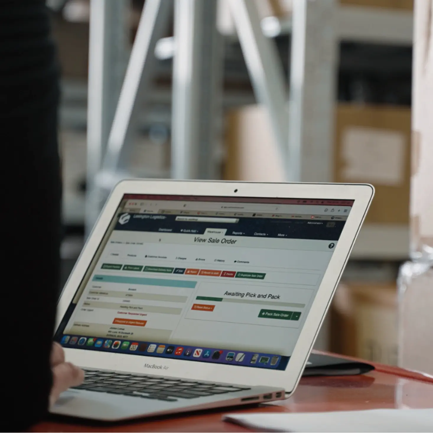 Laptop screen displaying a sales order management interface with status 'Awaiting Pick and Pack'.
