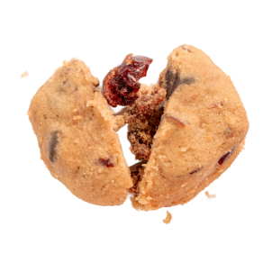 Broken cookie with visible dried cranberries and crumbs on a white background.