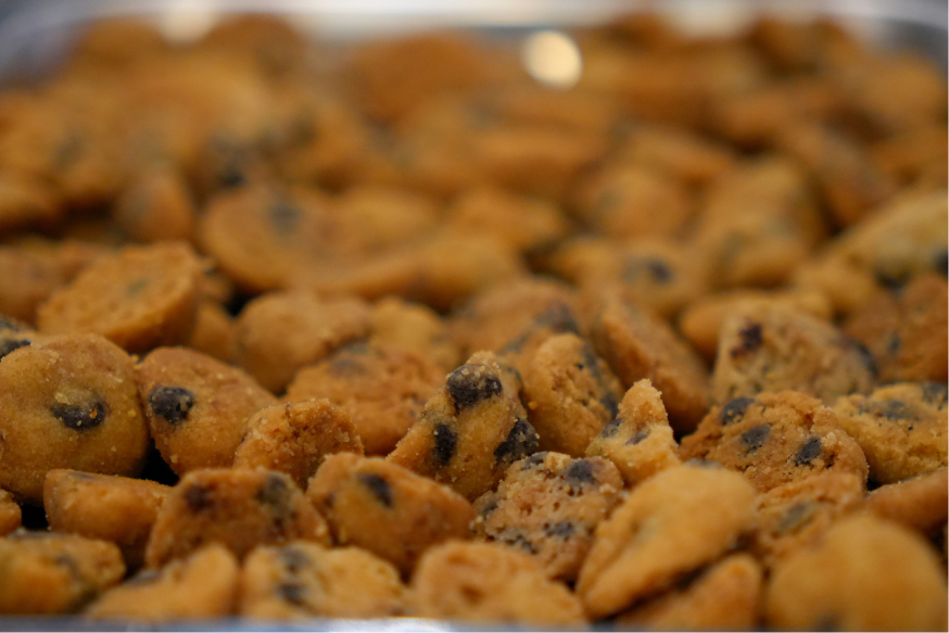 Close-up of small, round chocolate chip cookies piled together.