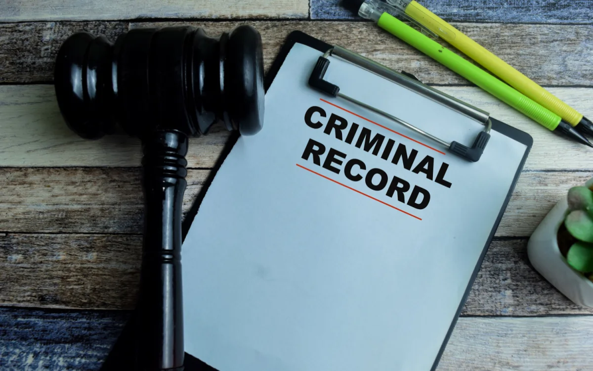 Clipboard labeled “Criminal Record” with a judge’s gavel, representing Nationally Coordinated Criminal History Checks (NCCHC) used by Australian employers in pre-employment screening.