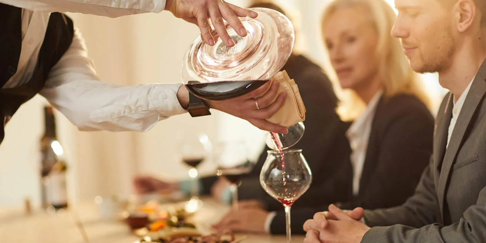 Happy friends cheering with red wine at countryside summer event.