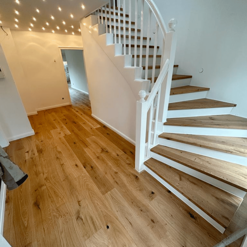 Neu verlegter Dielenboden mit passenden Treppenstufen im Wohnhaus