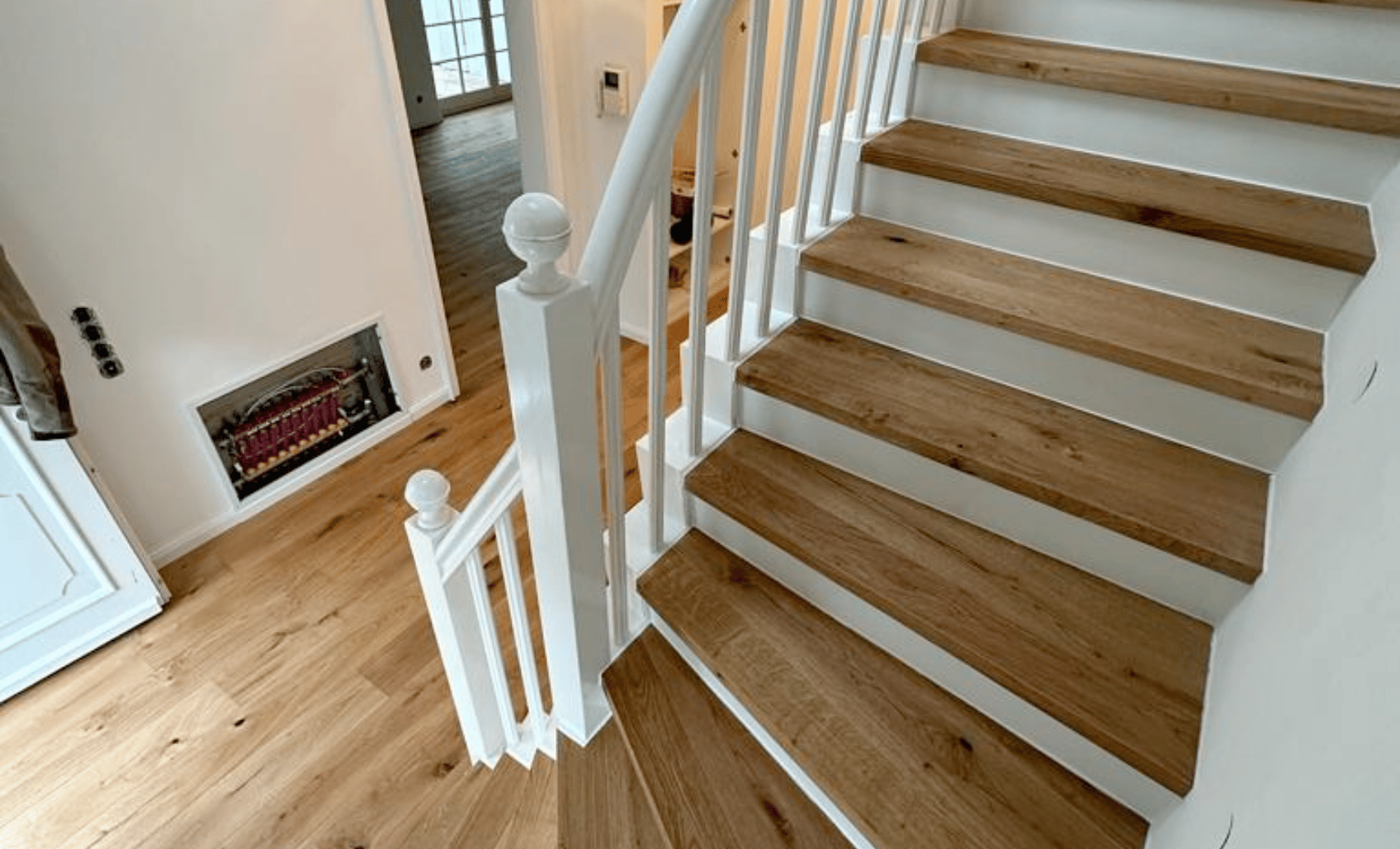 Renovierte Holztreppe mit Parkettstufen in heller Wohnumgebung