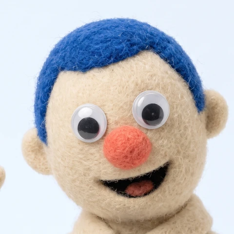SAM, the Face Up mascot: a smiling needle-felted puppet with blue hair
