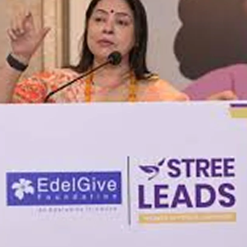 A woman speaking at a podium with banners of EdelGive Foundation and Stree Leads visible below her.