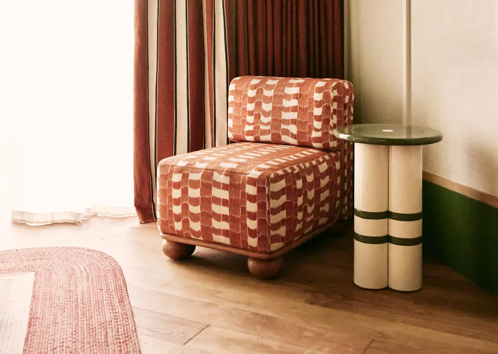 Coin salon rétro aux Cimes Bleues : fauteuil graphique rouge et table design dans les chambres et suites de votre hôtel au bord de mer et hôtel spa.