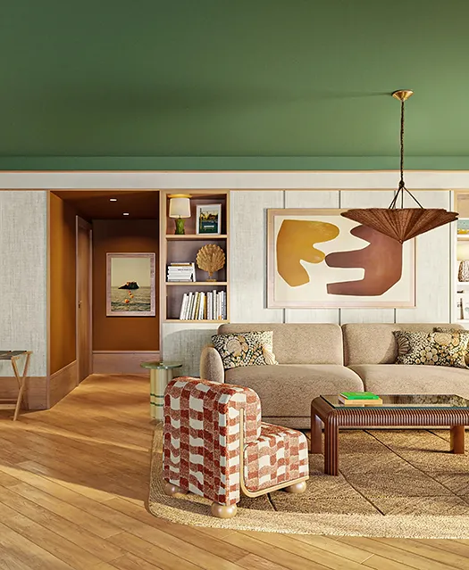 Salon spacieux de suite hôtelière avec canapé beige, fauteuil à carreaux rouges et blancs, parquet en chêne clair et plafond vert forêt.