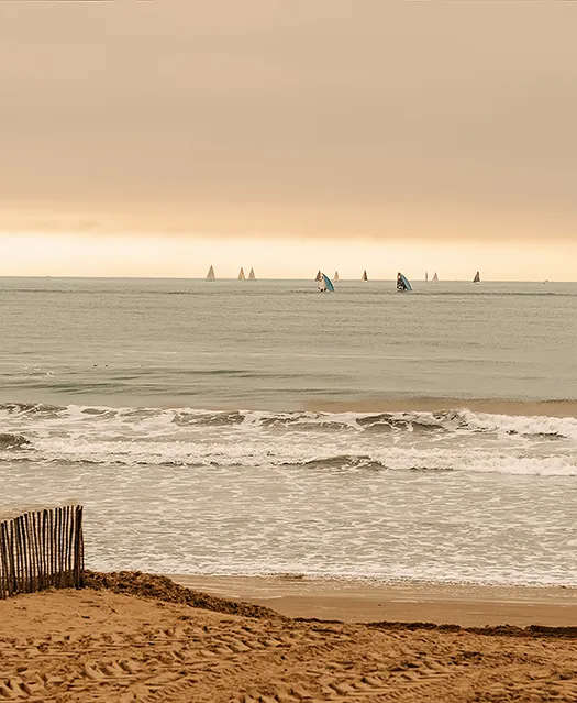 Vue sur la plage et l'océan Atlantique, avec des bateaux qui naviguent au loin.