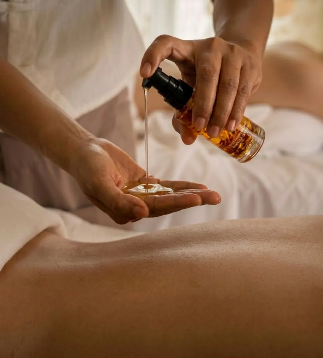 Massage relaxant au spa Cimes Bleues avec huile chaude appliquée sur le dos lors d’un soin bien-être