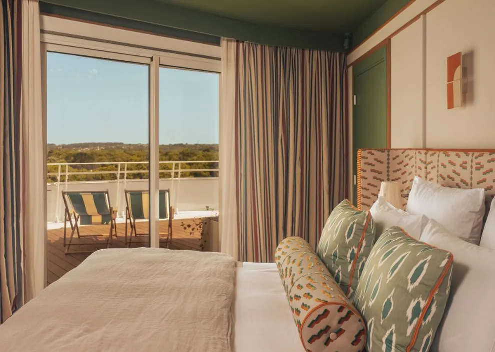 Style azur aux Cimes Bleues : touches bleues, rotin et lit king-size pour vos chambres et suites d'hôtel au bord de mer et hôtel spa.