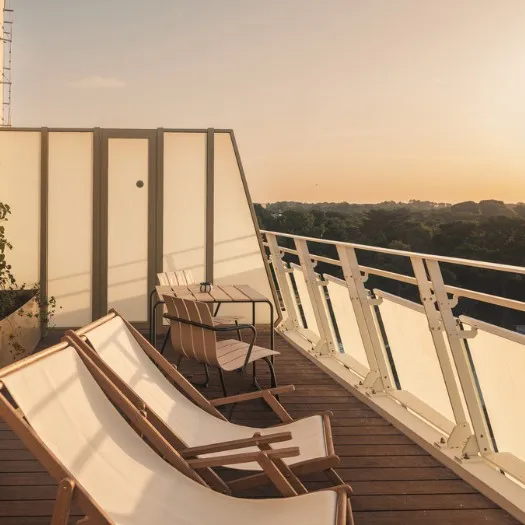 Terrasse de l'hôtel Les Cimes Bleues, hôtel bord de mer, avec coucher de soleil.