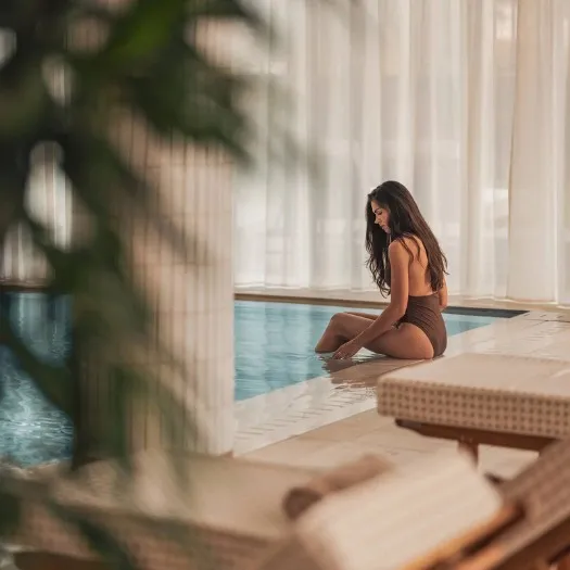 Une femme les pieds dans la piscine