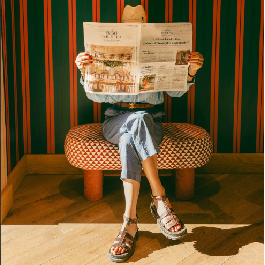 Femme lisant un journal dans un espace design à l'hôtel Les Cimes Bleues, hôtel bord de mer à La Baule.