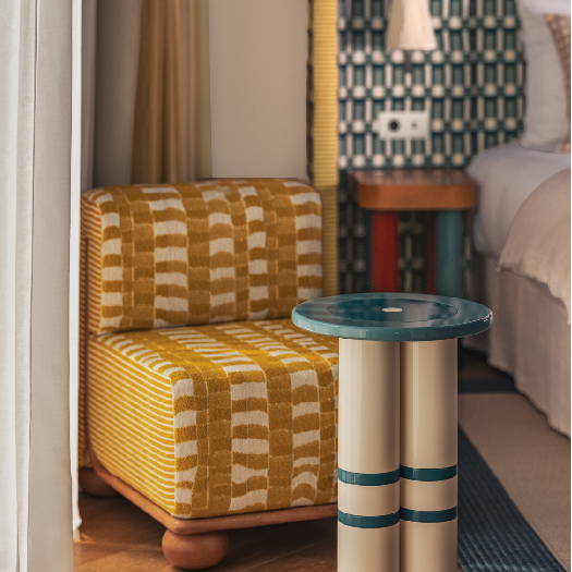 Focus d'un fauteuil et d'une table basse design, texturée et colorée dans la suite Prestige Mer Terrasse à l'hôtel bord de mer Les Cimes Bleues.