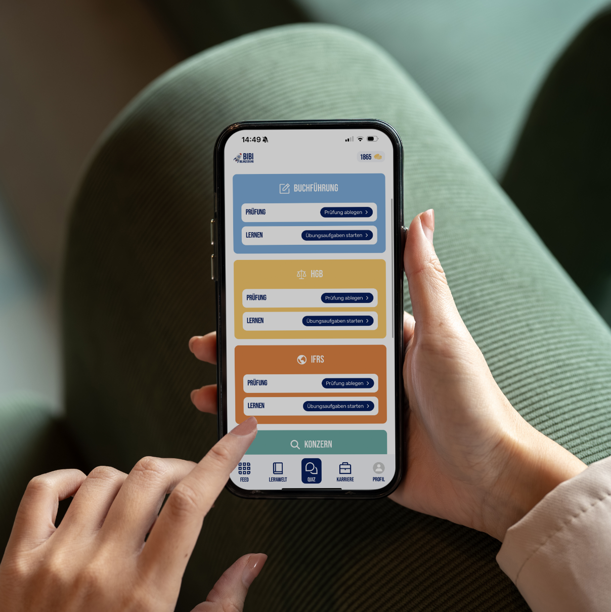 Person hält ein Smartphone und navigiert in einer Lern-App mit Kategorien Buchführung, HGB und IFRS, die Prüfungen und Übungen zum Starten anbietet.