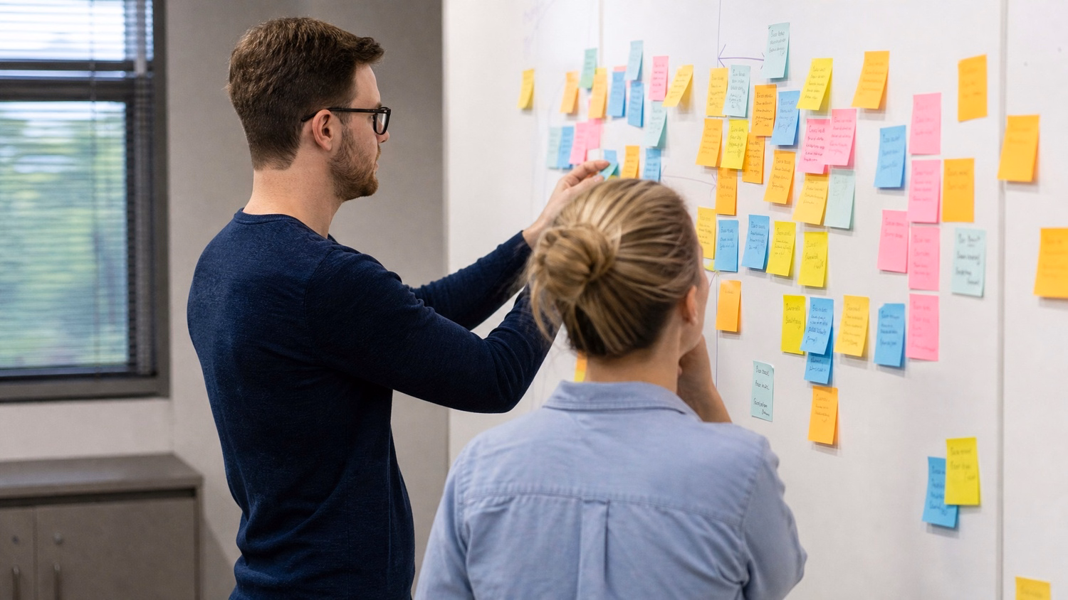 STICKY NOTE WALL, two people standing at a wall covered with colorful stick