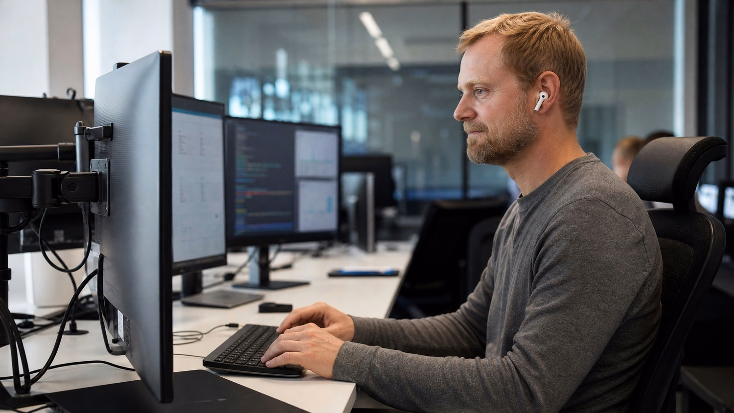 Man with earbuds types automated script on keyboard 60