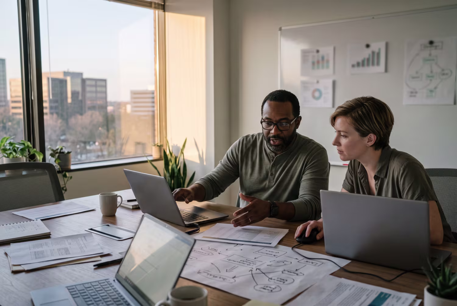 Two IT advisors discussing data security in sunlit office