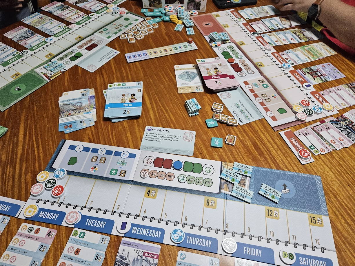 Gameplay photo of the board game Let's Go! To Japan: Grab Your Passport featuring various components and board state.
